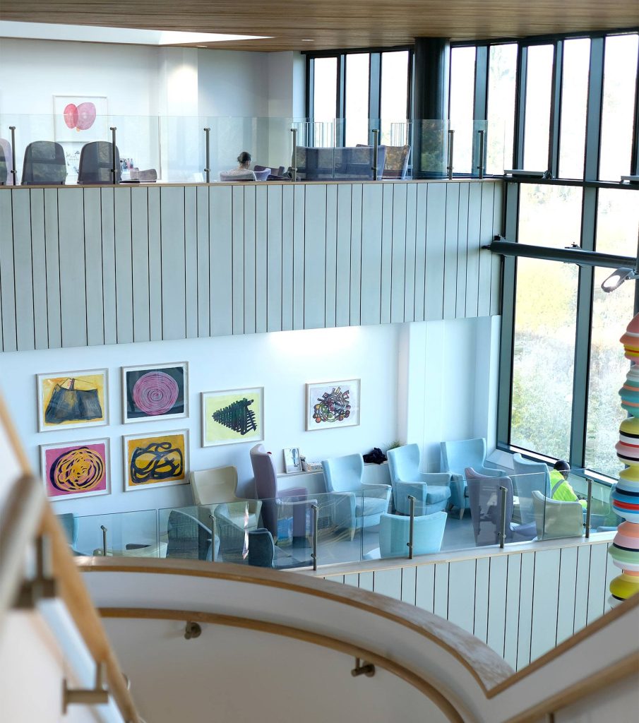 different-angle-of-hospital-reception-area-showing-windows-chairs-art-pieces-and-staircase