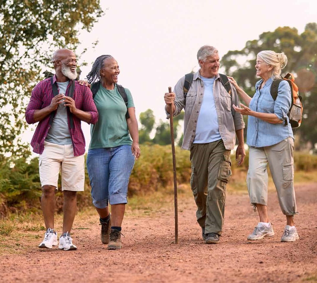 diverse-group-of-hikers-walking-through-natural-path-while-chatting
